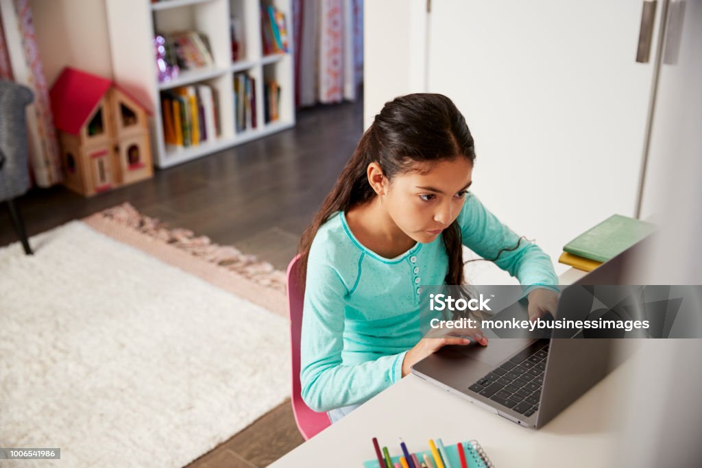 Junges Mädchen sitzen am Schreibtisch im Schlafzimmer mit Laptop, Hausaufgaben zu machen - Lizenzfrei Kind Stock-Foto