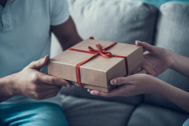 istock Close up. Girlfriend Giving Gift Box to Boyfriend. 1006542658