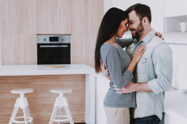 istock Young Happy Couple Hugging in Modern Kitchen. 1006542758