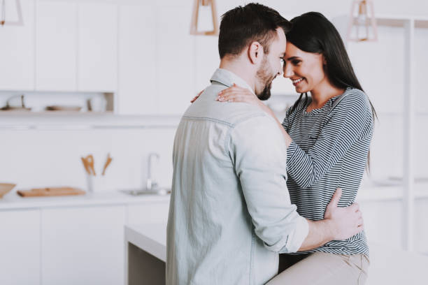 istock Young Happy Couple Hugging in Modern Kitchen. 1006542846