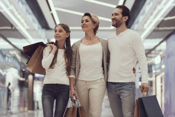 happy family of three in modern mall with bags. - boutique shopping retail mother imagens e fotografias de stock