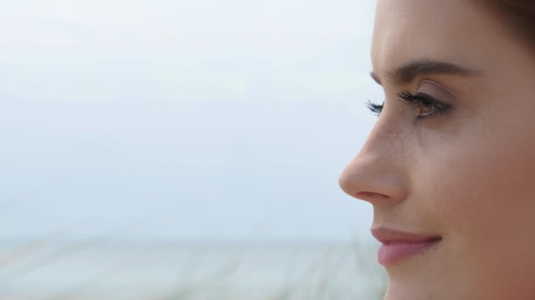 Close up young woman looking at out to sea.