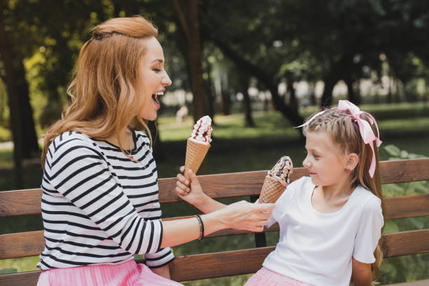 istock Modern mother having fun with her child eating ice cream 1006546504