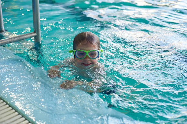 istock Little smiling boy swims in the pool. Close-up. 1006546624