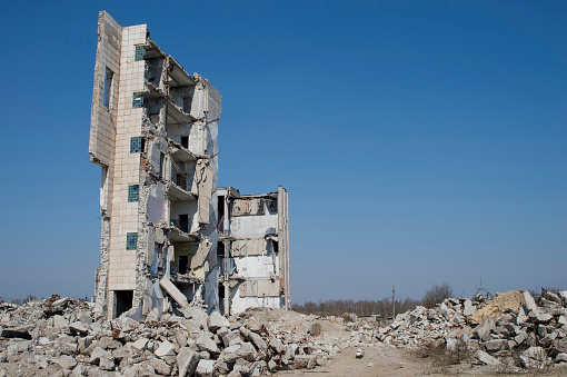 The wall of the destroyed building against the blue sky. Background, place of inscription.