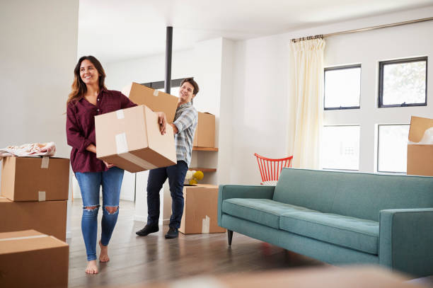 istock Excited Couple Carrying Boxes Into New Home On Moving Day 1006549410