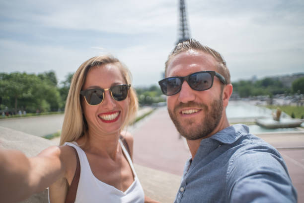 istock Young couple taking selfie in Paris city using mobile phone 1006559004