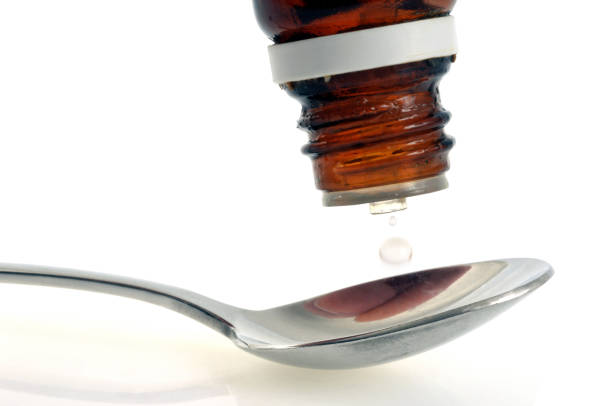Silver Spoon holding red liquid fading from front to back with a white background