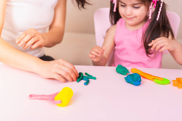 istock Mother and Cute girl playing with playdough 1006559436