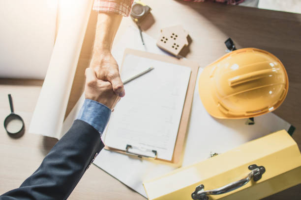 istock Top view of engineer and businessman shake hands on working table at working site 1006563046