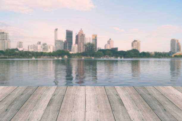 istock wood table for present your product on river and city background 1006563062