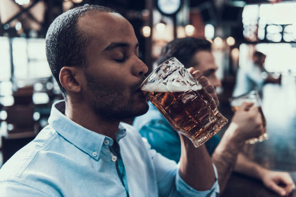 istock Young Smiling Men Drinking Beer in Modern Bar. 1006567106