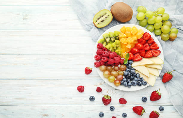 istock Fresh fruits in plate on wooden table 1006570286