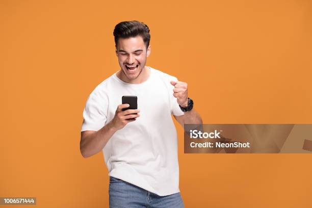 Sonriente A Hombre Guapo Con El Teléfono Móvil Sobre Fondo Amarillo Foto de stock y más banco de imágenes de Hombres