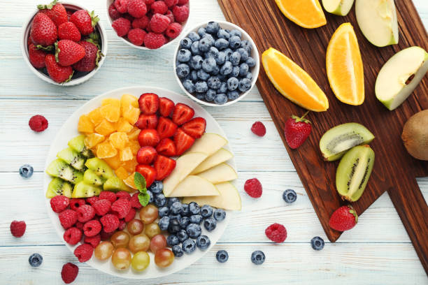 istock Fresh fruits in plate with cutting board on wooden table 1006571734