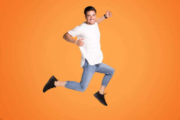 istock Happy handsome man jumping with big smile. 1006573860
