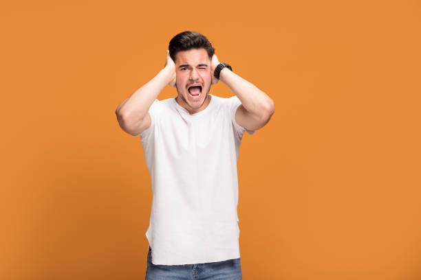 istock Disappointed young man on yellow background. 1006573952