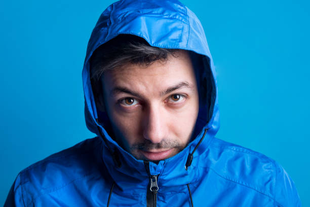 istock Portrait of a young man in a studio with anorak on a blue background. 1006581742