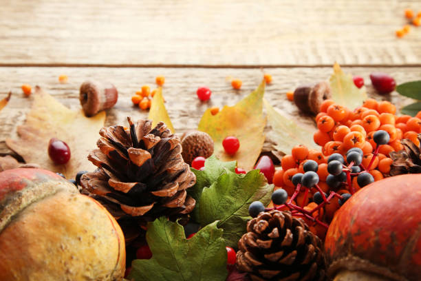 istock Autumn leafs with berries and cones on brown wooden table 1006582668