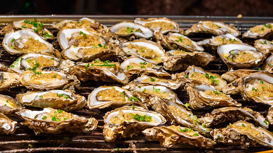 Grilled oysters with rice filling and herbs are sold in the Chinese market as a popular quick snack for tourists.