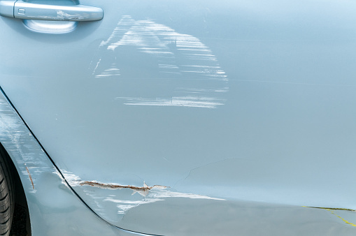 Cerrar puertas de rota y dañada plata automovilístico en accidente accidente con la pintura rayada en colisión photo