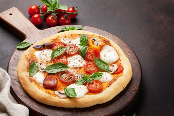 istock Italian pizza with tomatoes, mozzarella and basil 1006591176