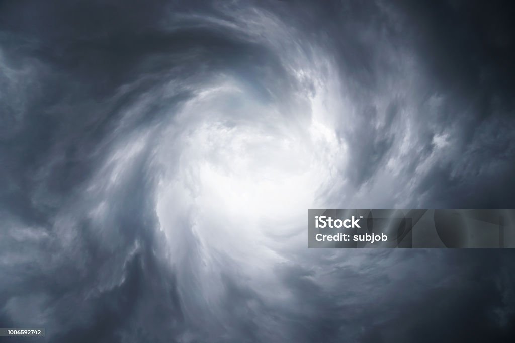 Dark, grim, stormy, rainy sky with rays of light. Scary hurricane clouds. Natural element. Stock Photo for your design Storm Stock Photo