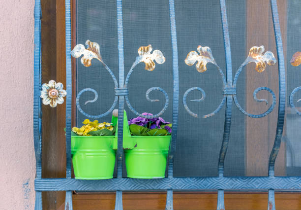 Flower pots stand on a window with iron bars in bodrum,Turkey