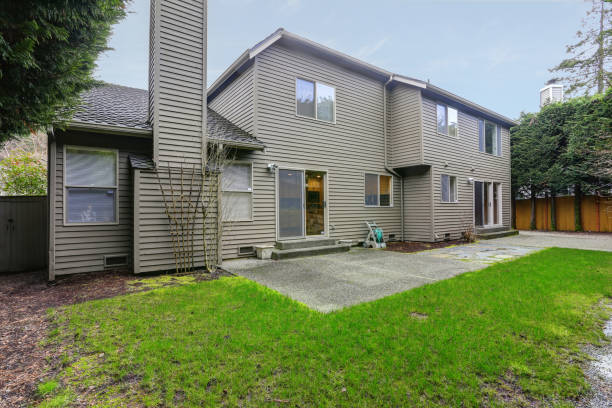 istock Private yard of a grey house with green grass. 1006597040