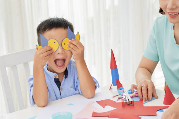 istock Excited boy closing eyes with paper birds 1006601496