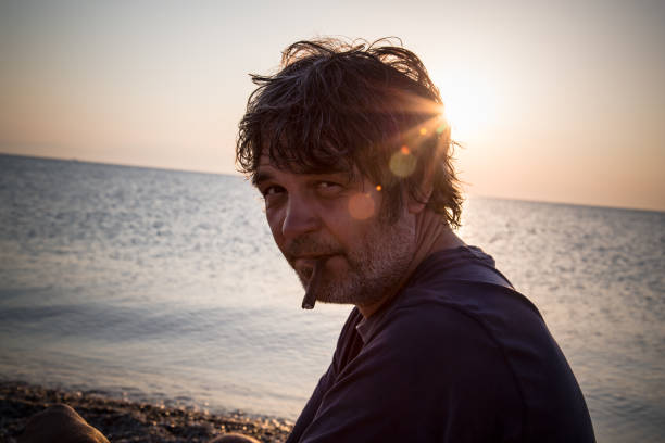 istock Handsome man relaxing on the beach in Greece while sunsets 1006607568