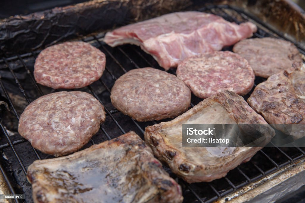 Meats being cooked on a gas grill Barbecue - Meal Stock Photo