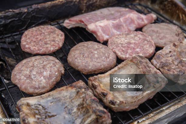 Meats Being Cooked On A Gas Grill Stock Photo - Download Image Now - Barbecue - Meal, Barbecue Grill, Beef