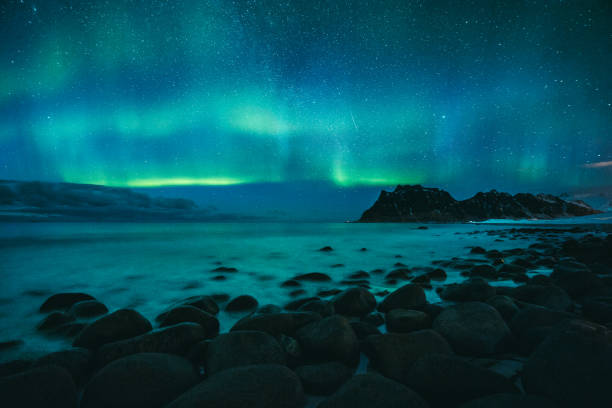 erstaunliche aurora borealis tanzen über berühmte uttakleiv strand in einer kalten arktischen nacht auf lofoten-inseln archipel im winter, norwegen, skandinavien - aurora borealis aurora polaris lapland finland stock-fotos und bilder