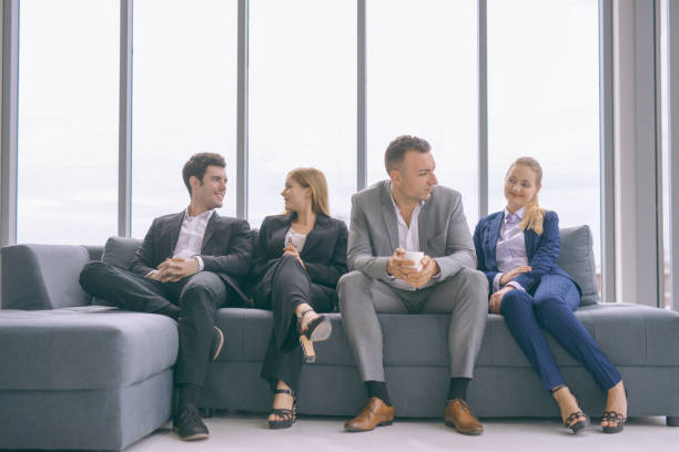 istock business people taking to each other on sofa in office 1006619216