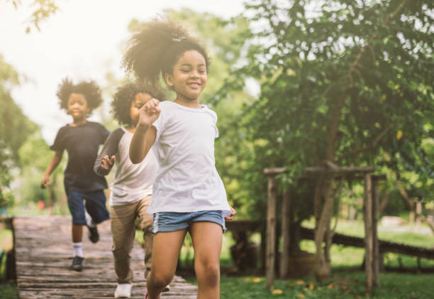 bambini che giocano all'aperto - spring child field running foto e immagini stock