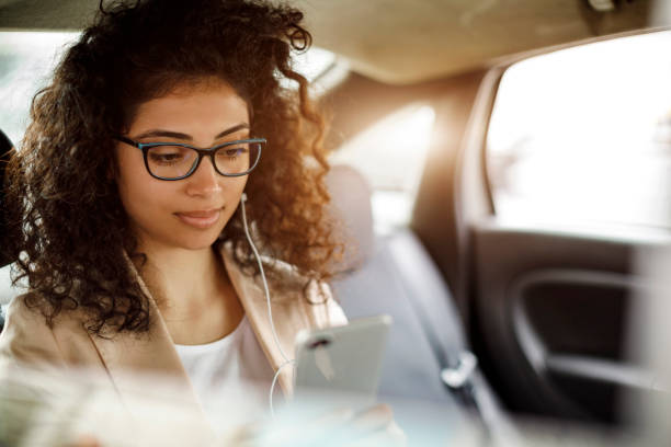 istock Businesswoman using smart phone in a car 1006620354