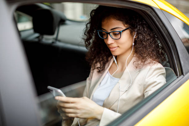 istock Businesswoman using smart phone while commuting to work by taxi 1006620530
