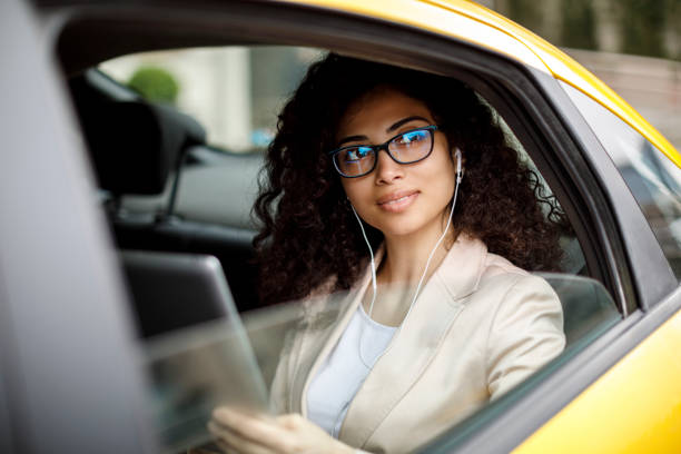 istock Young businesswoman using digital tablet in a taxi 1006620626