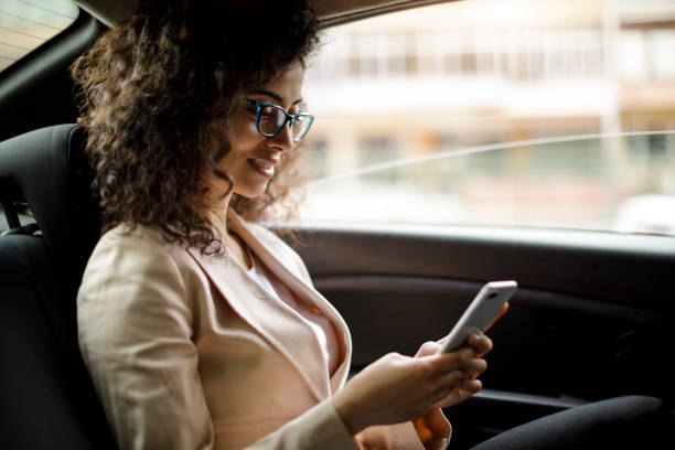 istock Businesswoman using smart phone in a car 1006620864