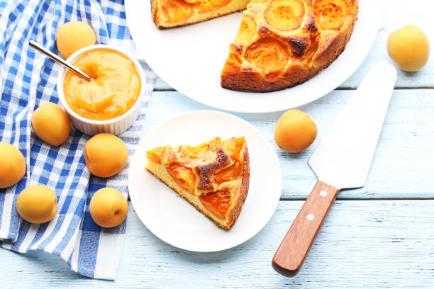 istock Slice of apricot pie with jam on blue wooden table 1006624168