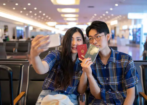 Multi-ethnic couple taking selfie pictures in airport