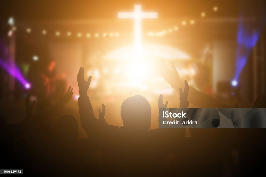 Christians raising their hands in praise and worship at a night music concert. Eucharist Therapy Bless God Helping Repent Catholic Easter Lent Mind Pray. Christian concept background. Praying Stock Photo