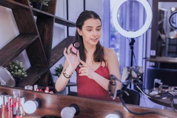 istock Beauty blogger filming video while standing near big light mirror 1006636890