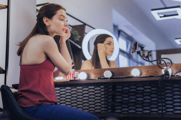 istock Dark-haired beauty blogger sitting near her makeup table 1006637148
