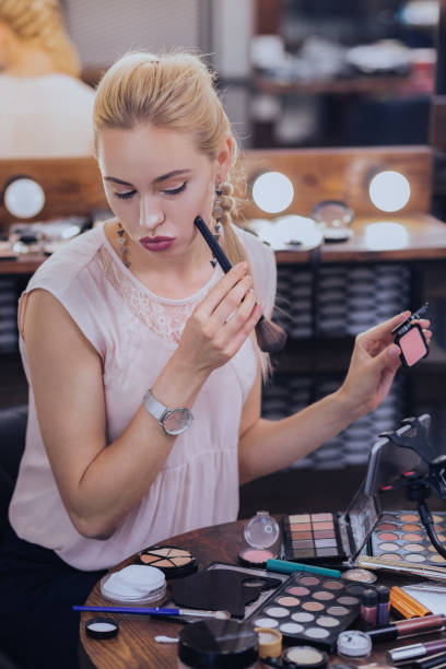 istock Professional makeup artist fixing hr cheekbones putting makeup on 1006639132