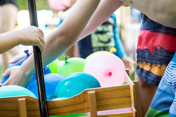 niños jugando a batalla de globos de agua en verano - picking a fight fotografías e imágenes de stock