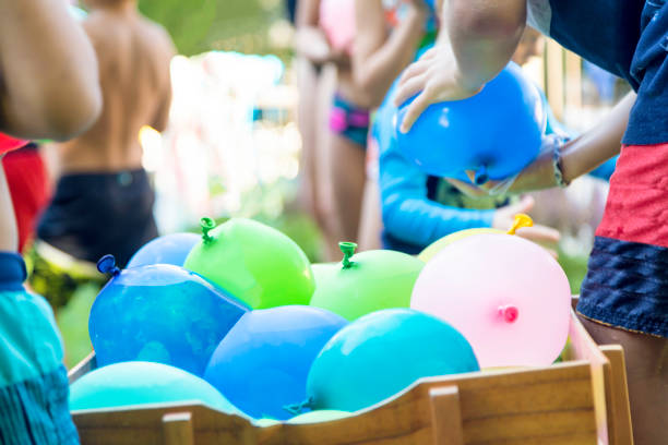 i bambini giocano a palloncini d'acqua combattono in estate - picking a fight foto e immagini stock