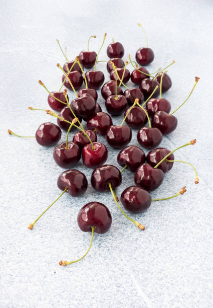 istock Sweet Cherries Scattered directly on Blue Background 1006648560