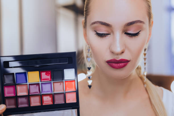 istock Woman with bright makeup showing her lip gloss palette 1006648996